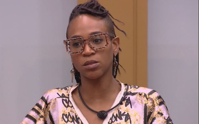 Karol Conká de óculos de grau com roupa estampada com detalhes em rosa