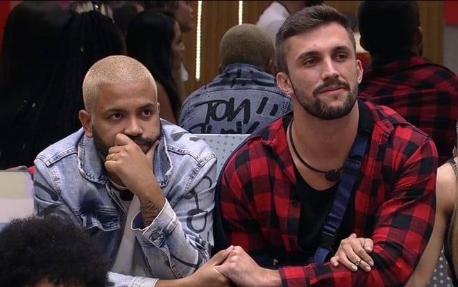 Imagem de Projota (à esq.) e Arthur Picoli de mãos dadas no BBB21