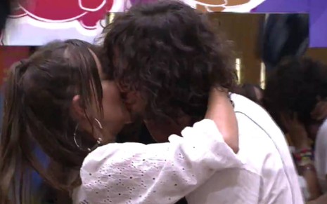 Thaís e Fiuk estão beijando; ela usa blusa branca e ele camiseta branca