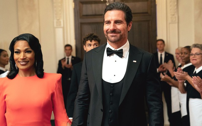 Com trajes de gala, Kron Moore e Ed Quinn caminham por um salão da Casa Branca em cena de The Oval
