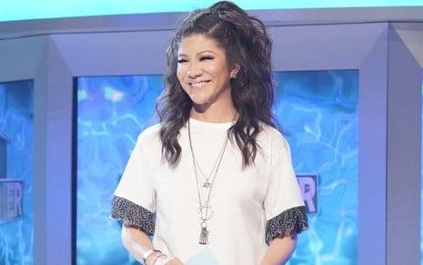 No palco da 21ª edição do Big Brother americana, Julie Chen Moonves veste branco, com um colar e cabelo amarrado