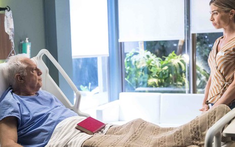 Antonio Fagundes deitado no leito de um hospital conversa com Grazi Massafera em cena da novela Bom Sucesso, da TV Globo