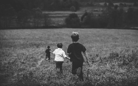Crianças correm no campo em foto de banco de imagens