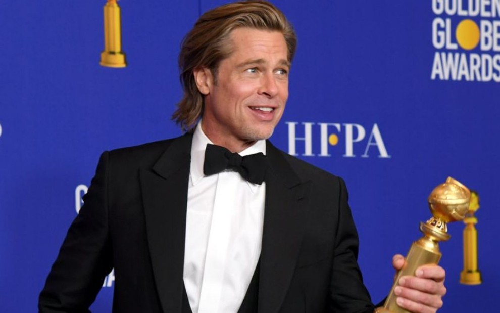 Foto de Brad Pitt com estatueta do Globo de Ouro na mão após vencer prêmio de melhor ator coadjuvante em comédia