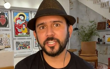 Bráulio Bessa de barba, chapéu preto e camiseta da mesma cor
