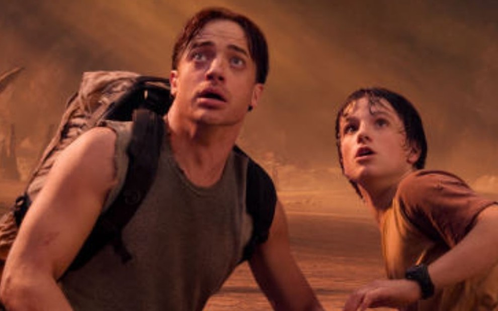 Brendan Fraser e Josh Hutcherson se agacham e estão com expressão de susto em cena de Viagem ao Centro da Terra - O Filme (2008)