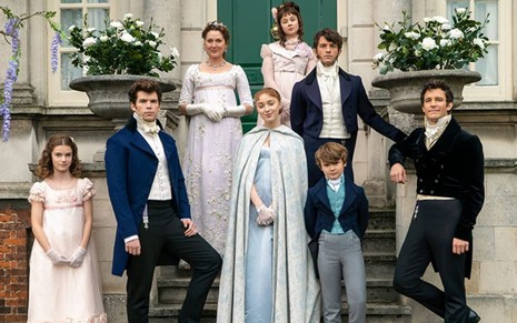 O elenco da família Bridgerton em foto de divulgação, com roupas de época, em frente a uma casa