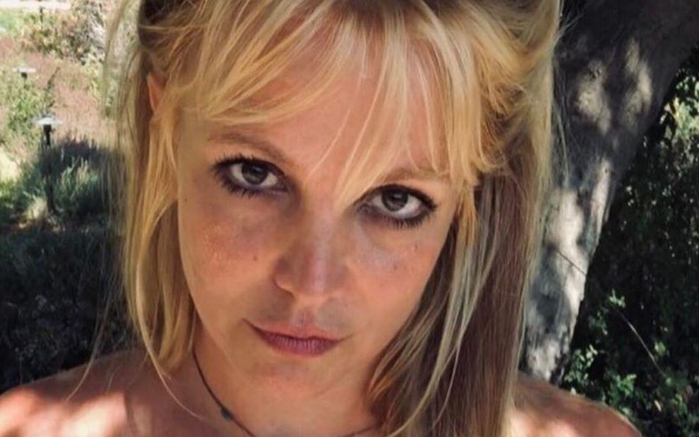 Imagem de Britney Spears de cabelo meio preso e blusa caída nos ombros