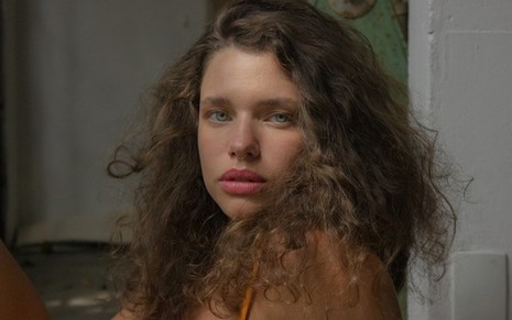 A atriz Bruna Linzmeyer faz expressão de mistério em pose na qual está com cabelos soltos e volumosos