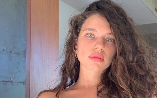 Imagem de Bruna Linzmeyer em ensaio fotográfico, com top preto e cabelos para a frente