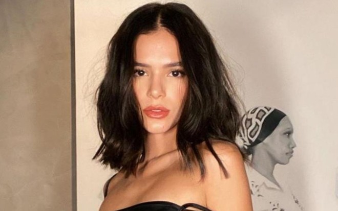 De vestido preto, a atriz Bruna Marquezine olha para a câmera em ensaio fotográfico