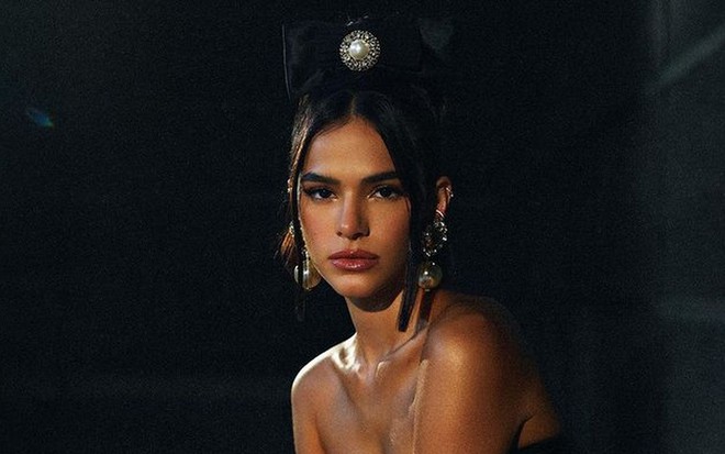 Bruna Marquezine de top preto, barriga de fora e laço com brilhante na cabeça