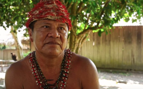 O cacique Juarez Saw Mundukuru sem camisa, com colares típicos indígenas, com expressão séria