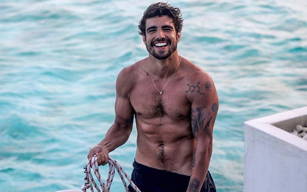 Caio Castro sem camisa na beira do mar