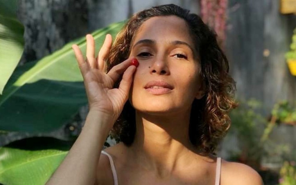 A atriz Camila Pitanga segura uma pitanga em frente ao rosto em foto publicada no Instagram