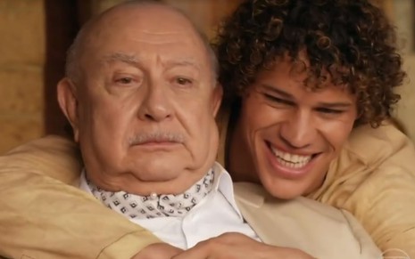 José Loreto abraça Sérgio Mambeti e sorri em cena gravada para a novela Flor do Caribe