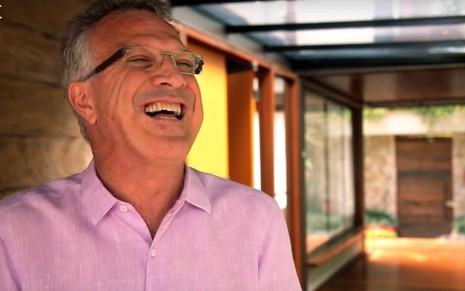 Pedro Bial de camisa rosa, rindo na área externa de sua casa, em episódio do programa Casa Brasileira, do GNT