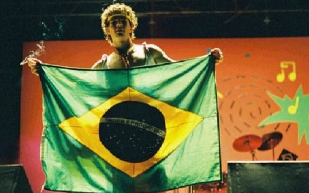 Daniel de Oliveira segura uma bandeira do Brasil estendida