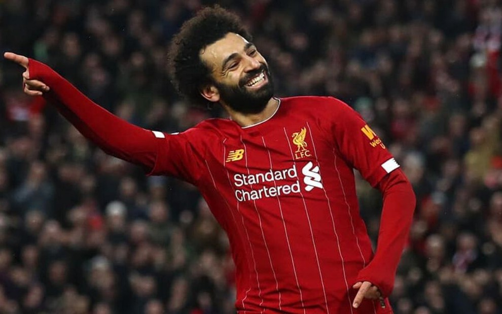 Atacante do Liverpool, Mohamed Salah sorri e aponta o dedo para o lado ao comemorar um gol