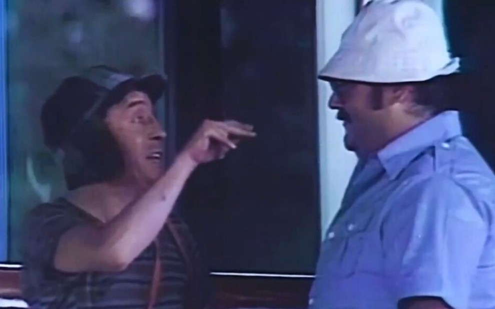 Chaves (Roberto Bolaños) faz sinal com a mão para Seu Barriga (Edgar Vivar) no episódio de Acapulco