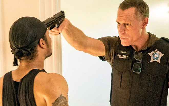 De bandana na cabeça, Phil Rice tem a testa pressionada por uma pistola no punho de Jason Beghe em Chicago P.D.