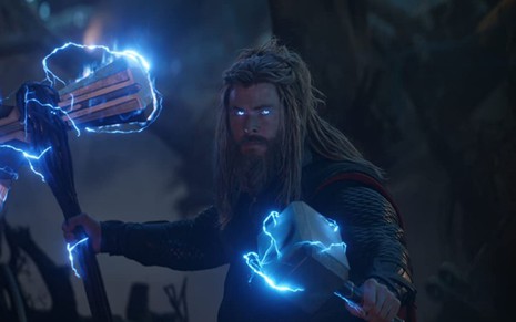 Chris Hemsworth segura um martelo e um machado em cena de Vingadores: Ultimato (2019)