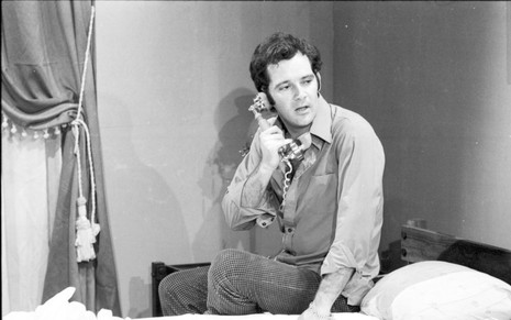Cláudio Marzo em foto preto e branco atende ao telefone em cena de A Grande Mentira