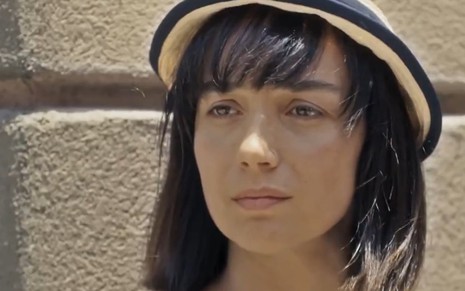 A atriz Simone Spoladore com uma expressão triste e usando um chapéu em cena como Clotilde de Éramos Seis