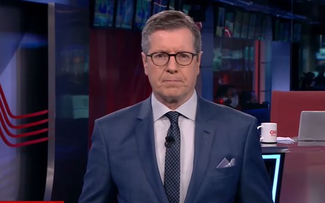 De terno e gravata, Márcio Gomes está sério no cenário do CNN Prime Time, da CNN Brasil