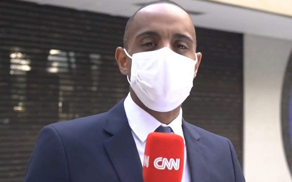 O jornalista Jairo Nascimento, da CNN, usa máscara em reportagem na rua