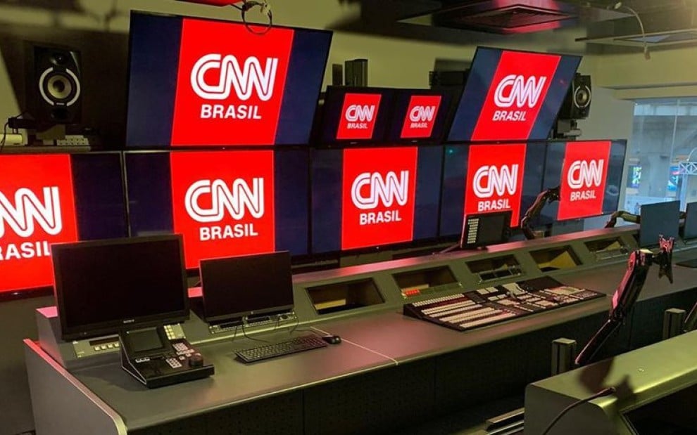 Telas de televisão dentro de um estúdio exibindo o logotipo da CNN Brasil