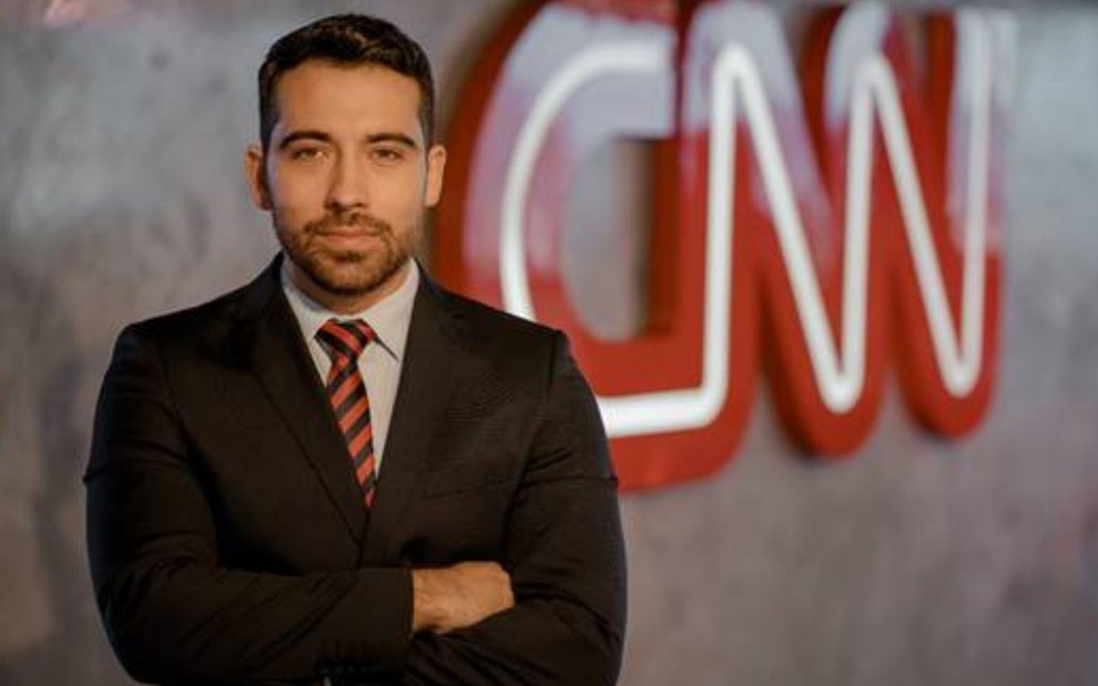 Gustavo Uribe em frente a um letreiro da CNN