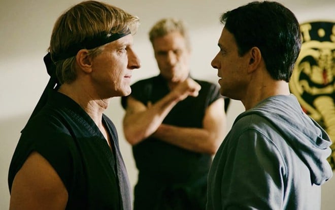 William Zabka encara Ralph Macchio com Martin Kove observando em cena de Cobra Kai