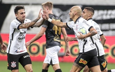 Os jogadores de futebol Gustavo Mosquito e Fábio Santos batem as mãos em comemoração a um gol na partida entre Corinthians e Ceará, jogo exibido pela Globo