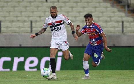 O jogador, Daniel Alves, em lance pelo São Paulo vestindo o uniforme branco do time