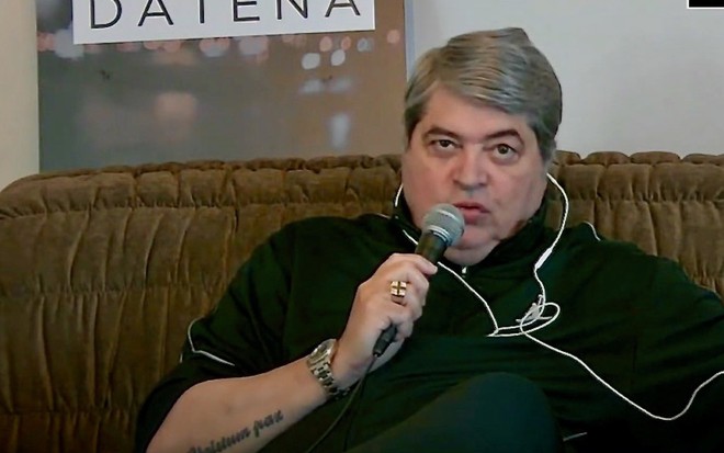 Imagem de José Luiz Datena no sofá de sua casa enquanto entrevista Leo Dias para o seu canal no YouTube