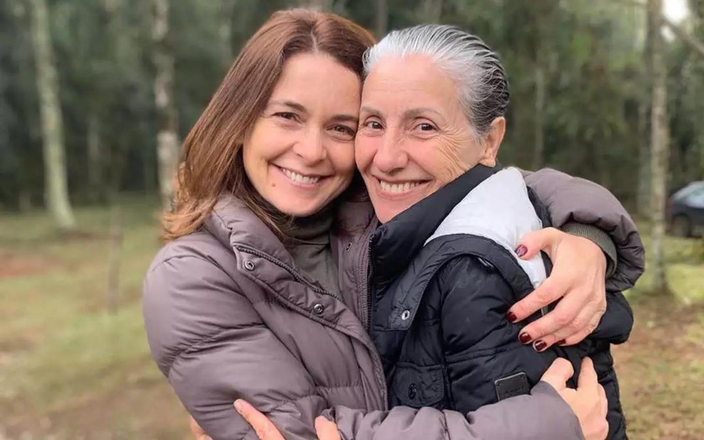 Cláudia Abreu e Cassia Kis abraçadas, agasalhadas e sorrindo durante as gravações de Desalma