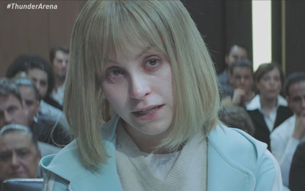 Com expressão de cansaço, Carla Diaz está em um tribunal em cena do filme O Menino que Matou Meus Pais