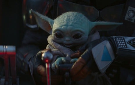 Baby Yoda observa controles de nave em cena da série The Mandalorian