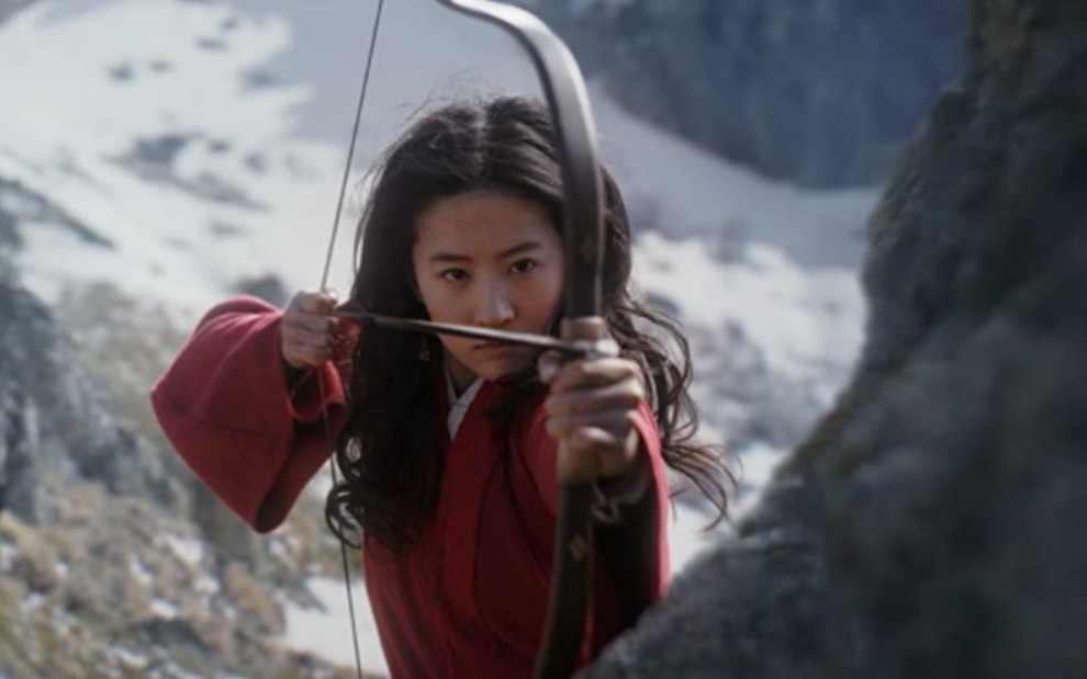 A atriz Liu Yifei segura arco e flecha como a personagem Hua Mulan no filme Mulan, da Disney