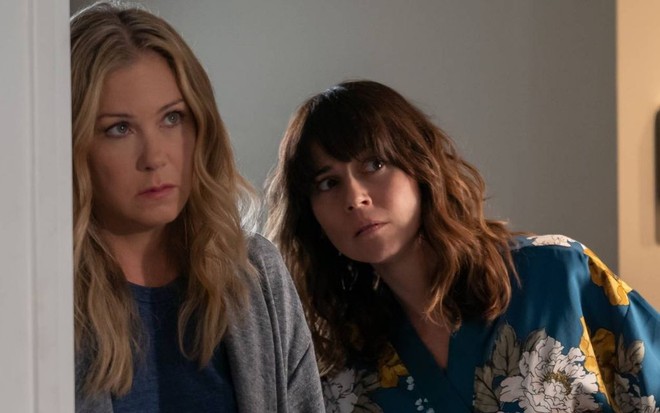 Brava, Christina Applegate abre uma porta com uma desconfiada Linda Cardellini logo atrás em cena de Disque Amiga para Matar