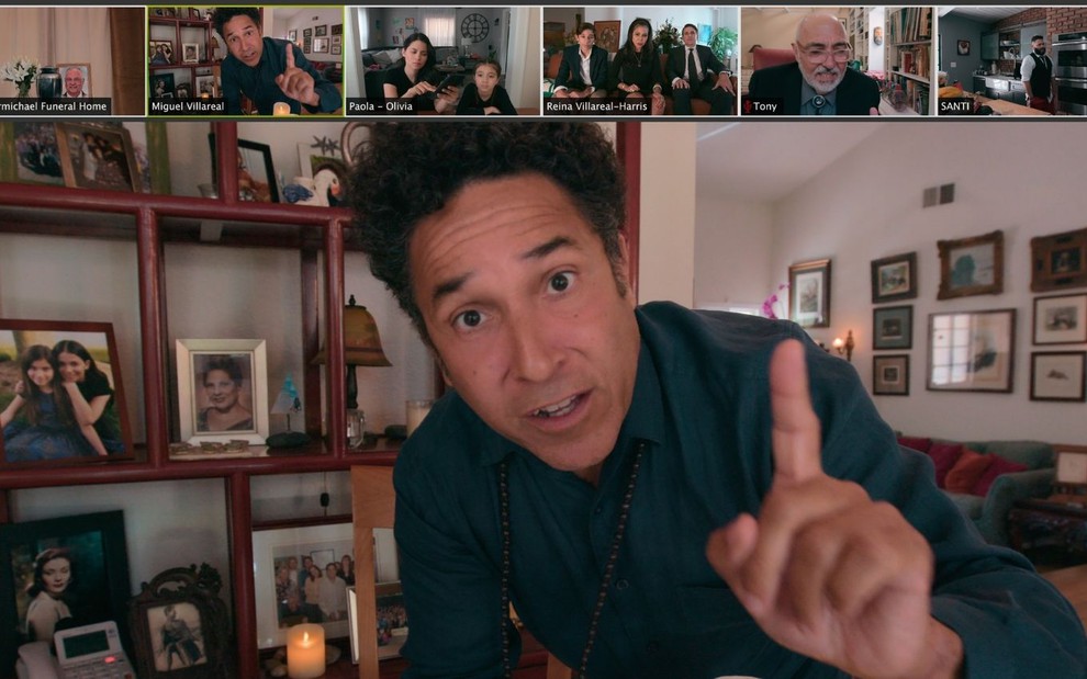 Em uma programa virtual de videoconferência, Oscar Nunez levanta o dedo indicador em cena da série Distanciamento Social