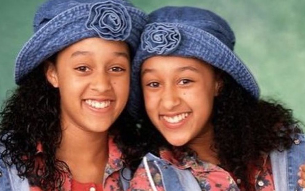 As atrizes Tia e Tamera Mowry sorriem em imagem de divulgação da série Irmã ao Quadrado, da Disney