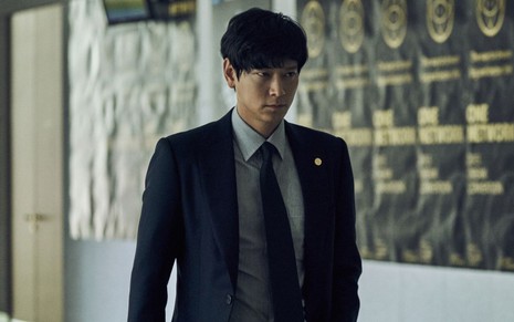 O ator Gang Dong-Won com expressão séria no filme Golpe de Mestre (2016)