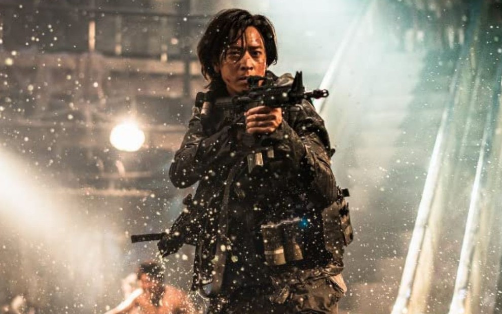 Gang Dong-Won anda com uma arma apontada para frente em cena do filme Invasão Zumbi 2 - Península (2020)