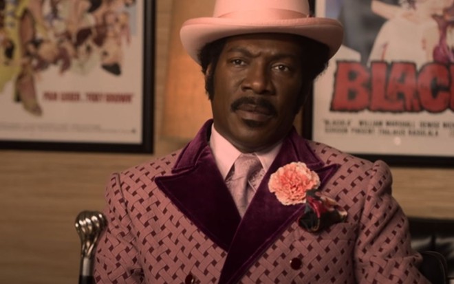 Eddie Murphy usa terno e chapéu rosa em cena de Meu Nome é Dolemite