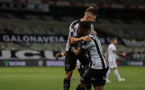 Eduardo Sasha e Keno comemoram gol do Atlético-MG, eles se abraçam em campo, ambos com  uniforme do time nas cores preto e branco