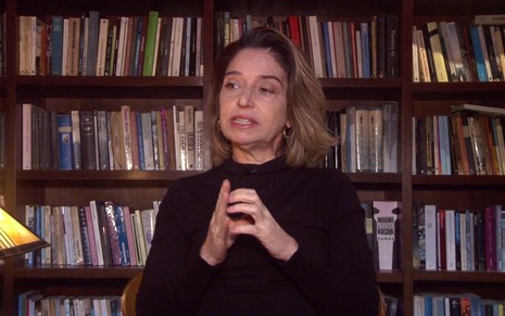 Elena Soarez aparece em frente a uma estante de livros em entrevista da O2 Filmes