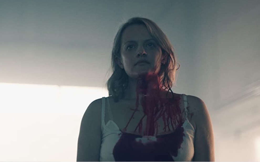 Elisabeth Moss suja de sangue no pescoço e na roupa em cena de The Handmaid's Tale
