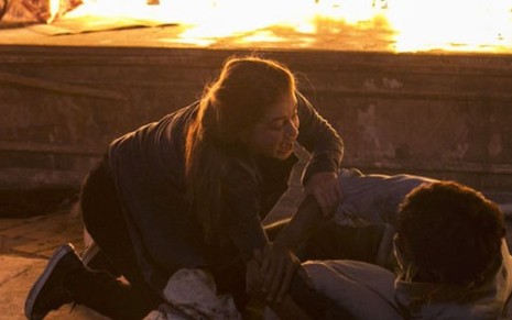 Em incêndio, Marina Ruy Barbosa (Eliza), com expressão de desespero, tenta ajudar Felipe Simas (Jonatas)